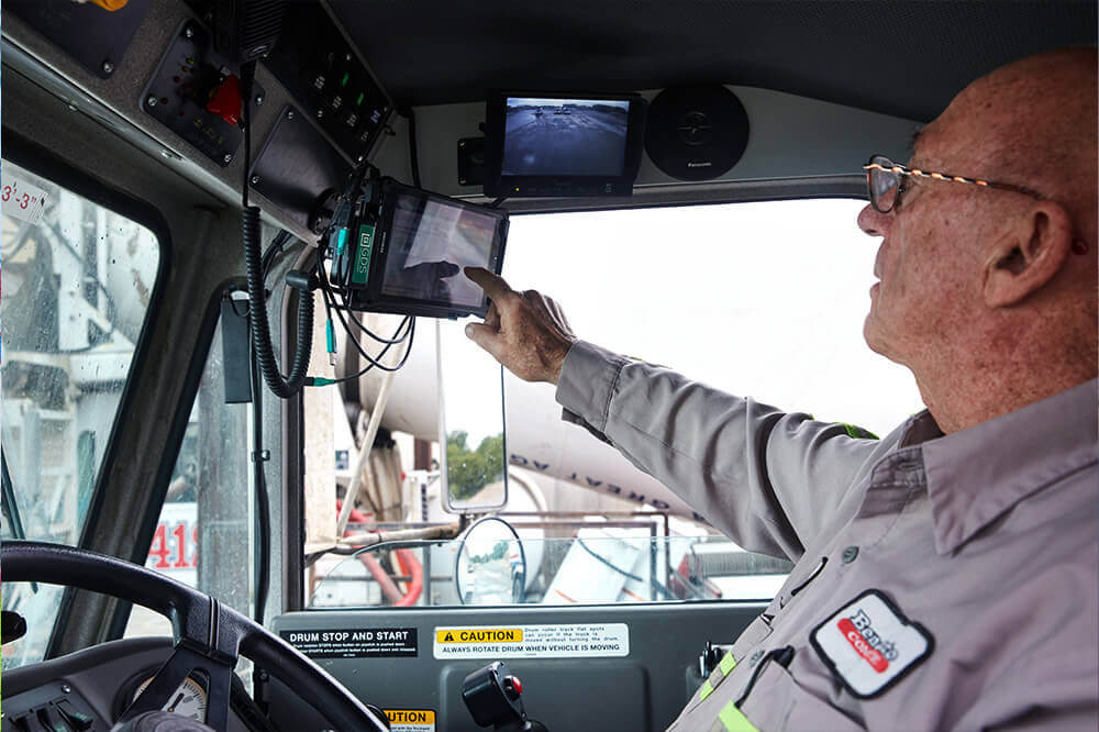 man in truck cab touching a touch screen tablet